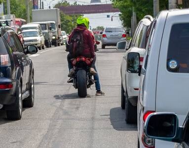 Motorcyclist stops between two cars